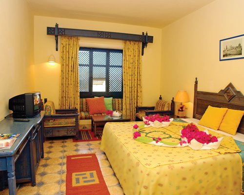 An open plan bedroom and living area with a television.
