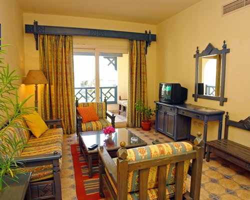 A well furnished living room with a television and balcony.