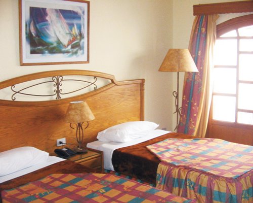 A well furnished bedroom with two twin beds and outside view.