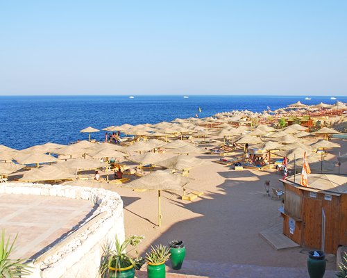 Pathway leading to the beach with sunshades alongside the water.