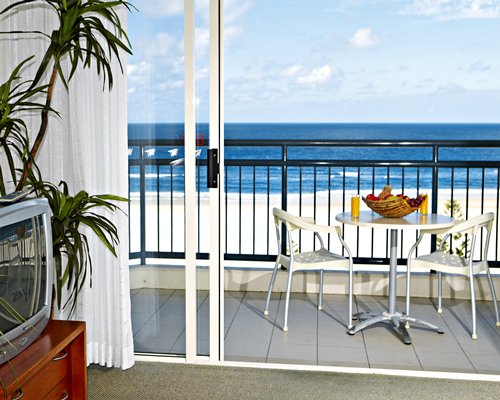 A balcony with dining area and the beach view.