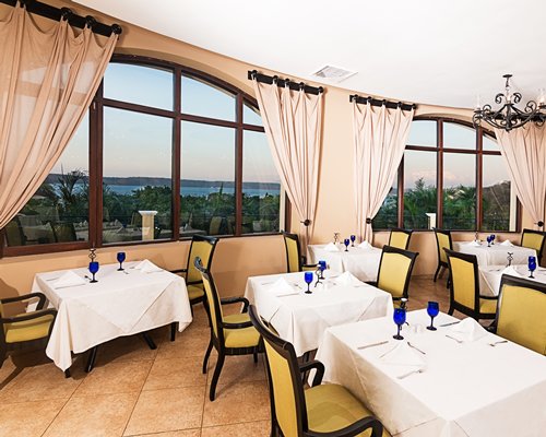 A restaurant with multiple dining tables with windows and outside view.