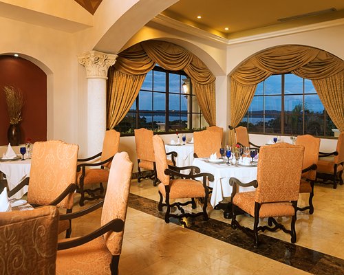 A restaurant with multiple dining tables with windows and outside view.