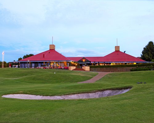 A pathway in a well maintained lawn leading to the resort.