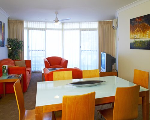 A well furnished living room with television and dining area.