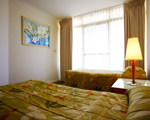 A well furnished bedroom with two beds and an outside view.