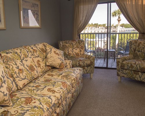 A well furnished living room with a balcony and patio furniture.