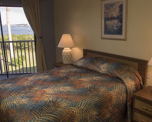 A well furnished bedroom with a queen bed and outdoor view.