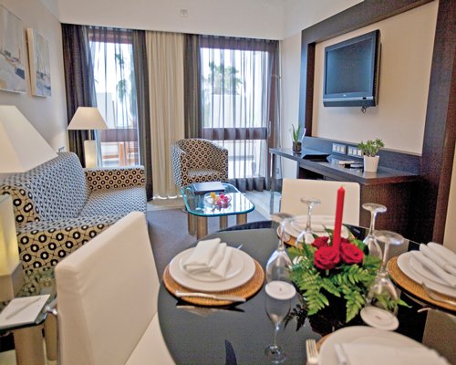 An open plan living and dining area with a television and outside view.