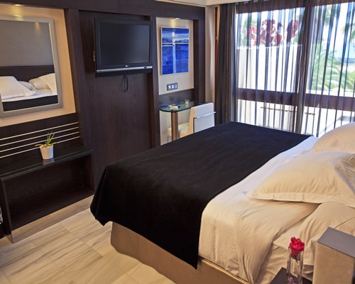 A well furnished bedroom with a mirror and patio.