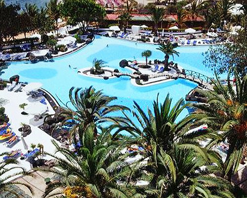 A large outdoor swimming pool with chaise lounge chairs.