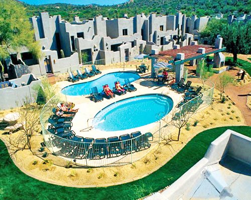 Villas of Cave Creek with outdoor swimming pools and chaise lounge chairs.