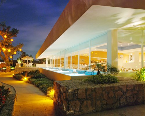 An exterior view of Presidente Intercontinental Cozumel resort at night.