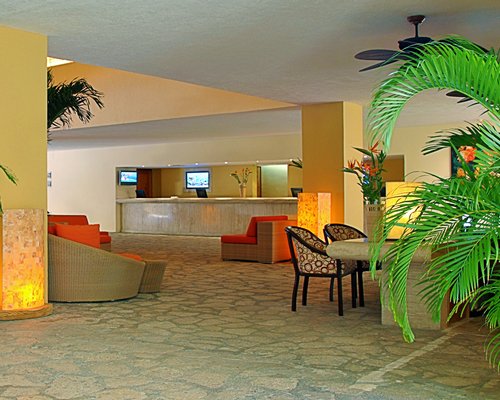 Reception lobby and lounge area of the Presidente Intercontinental Cozumel resort with television.