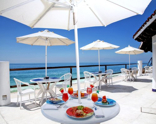 An outdoor fine dining restaurant alongside the ocean.