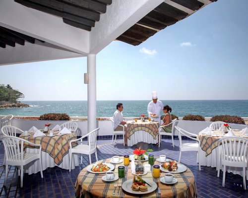 An outdoor fine dining restaurant alongside the ocean.