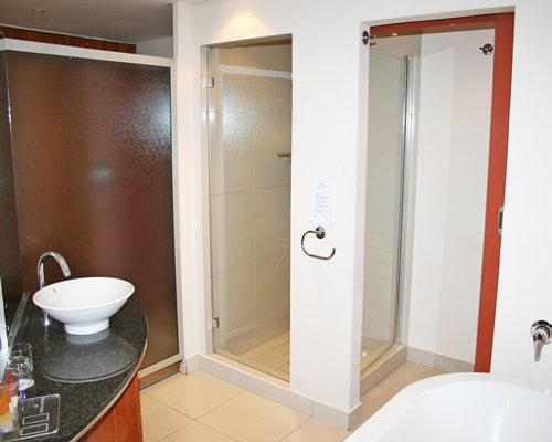 A bathroom with a shower bathtub shower stall and closed sink vanity.