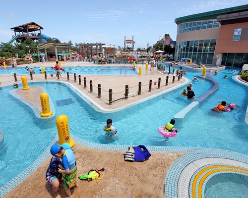 View of people and kids at a lazy pool with a water park.