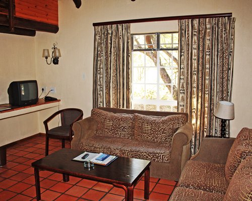 A well furnished living room with a television and outside view.