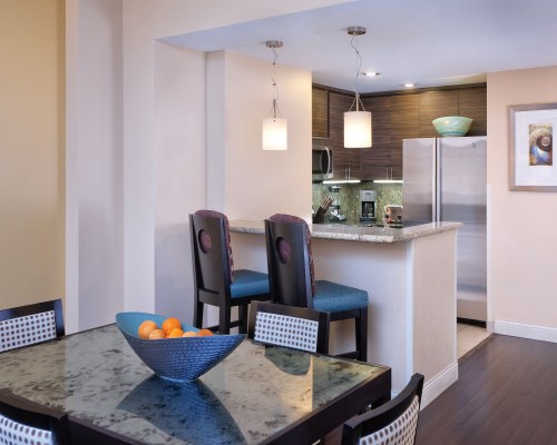A WELL EQUIPPED KITCHEN WITH BREAKFAST BAR AND DINING TABLE.