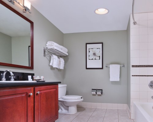 A BATHROOM WITH BATHTUB SHOWER AND A SINGLE SINK VANITY.