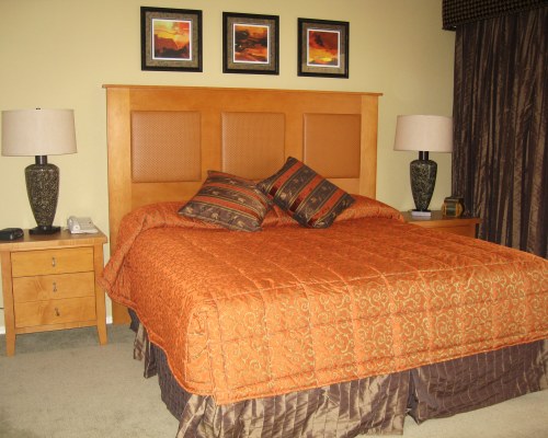 A WELL FURNISHED BEDROOM WITH A KING BED.