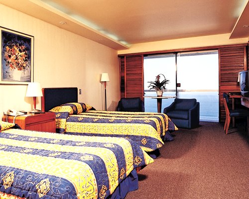 A well furnished bedroom with two beds and a balcony.