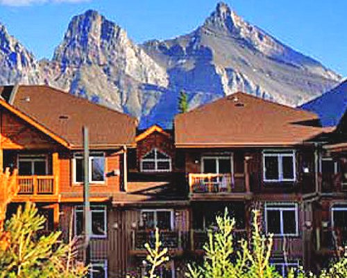 Exterior view of a unit with multiple balconies alongside mountains.