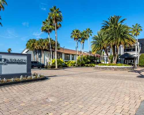 Exterior view of Legacy Vacation Club Orlando  Oaks with outdoor swimming pool and palm trees.