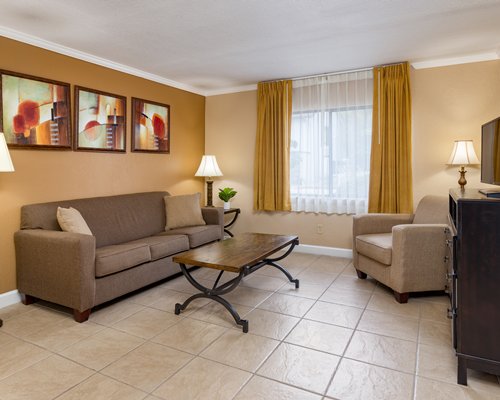 A well furnished living room with television dining area and bedroom with king bed.