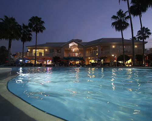 An outdoor swimming pool alongside the resort at night.