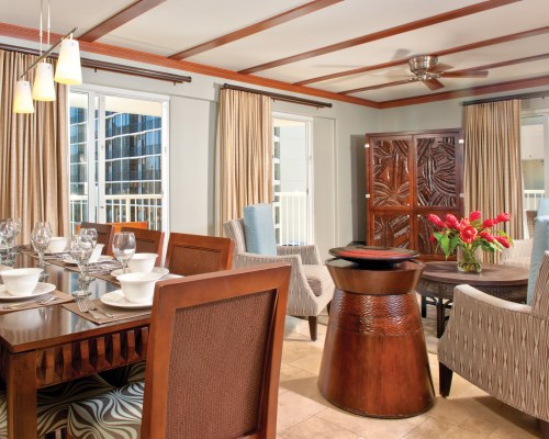 An open plan living room with a wooden dining table.