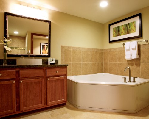 A bathroom with bathtub and single sink vanity.