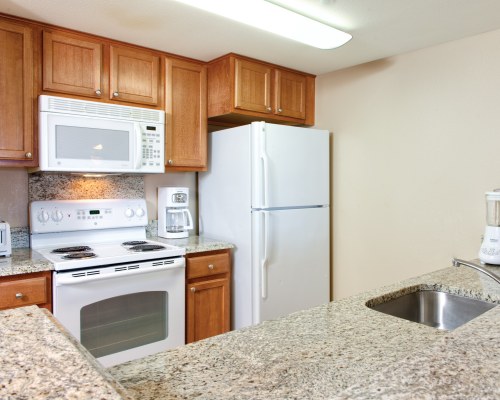 A well equipped kitchen with a microwave oven and refrigerator.