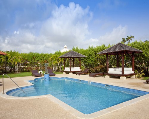 Outdoor swimming pool with chaise lounge chairs and gazebo.