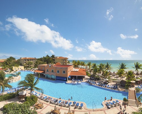 The Hotel Marina El Cid Spa & Beach Resort with outdoor swimming pool alongside the beach.