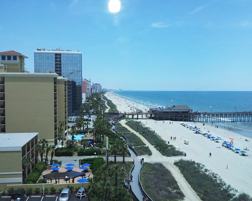 Exterior view of Carolina Grande alongside the ocean with wooden pier.