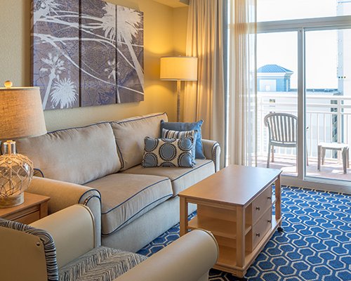 A well furnished living room with double pull out sofa and a balcony.