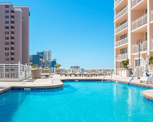 An outdoor swimming pool with chaise lounge chairs.