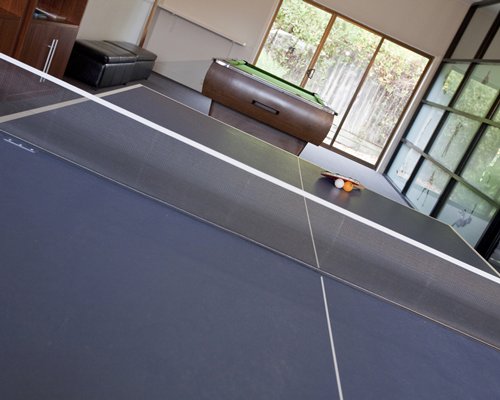 An indoor recreational area with a pool table and a ping pong table.