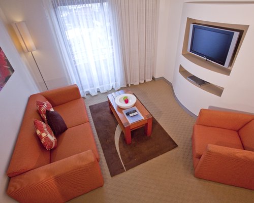 A well furnished living room with a television and an outside view.