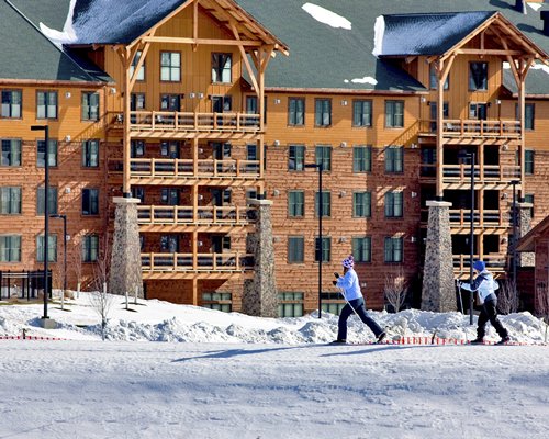 An exterior view of Hope Lake Lodge Resort & Indoor Waterpark At Greek Peak resort with snow.
