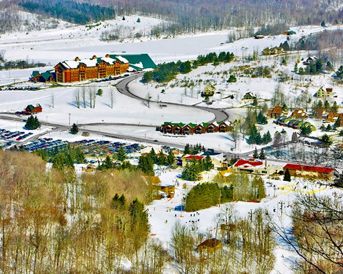 View of Hope Lake Lodge Resort & Indoor Waterpark At Greek Peak surrounded by wooded area.