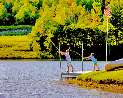 A view of two kids fishing in the lake.