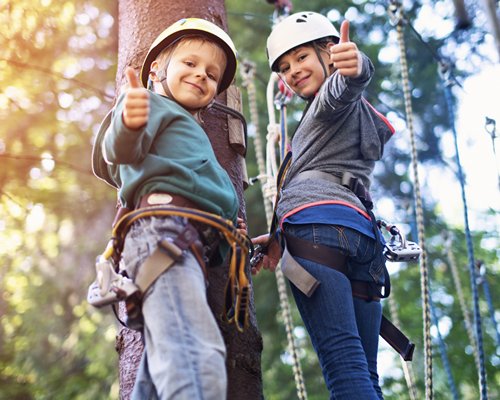 View of kids at the wooded area Zip lining.