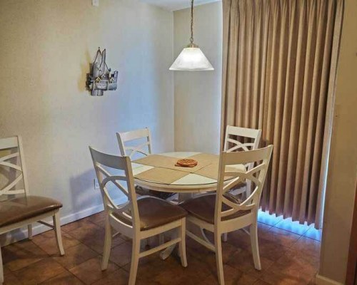 A WELL FURNISHED LIVING AREA WITH PULL OUT SOFA ALONGSIDE THE DINING AREA AND A KITCHEN.
