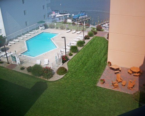 SCENIC AERIAL VIEW OF THE OUTDOOR SWIMMING POOL WITH CHAISE LOUNGE CHAIRS AND PATIO FURNITURE.