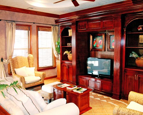 A well furnished living room with a television sofas and an outside view.