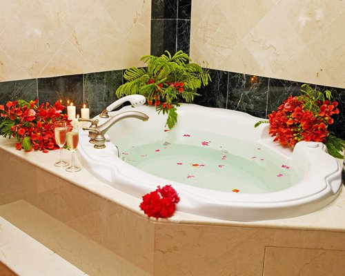 A bathtub covered with flower pedals.