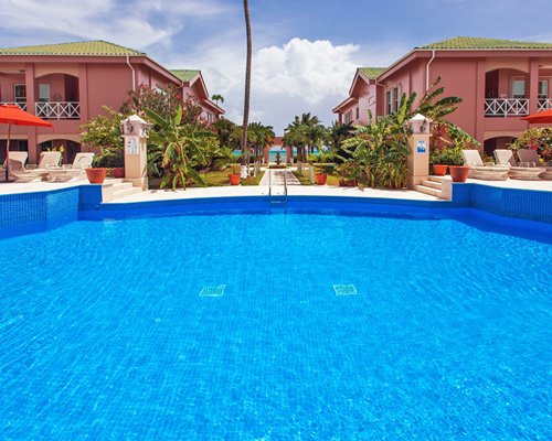An outdoor swimming pool with chaise lounge chairs alongside the resort.
